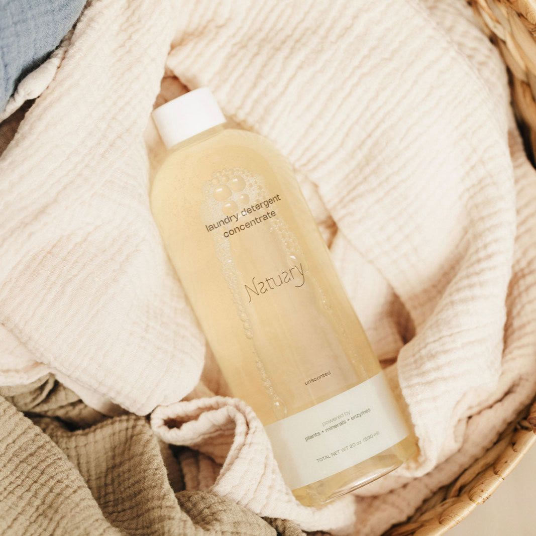 Bottle of Natuary laundry detergent on a textured surface with neutral tones