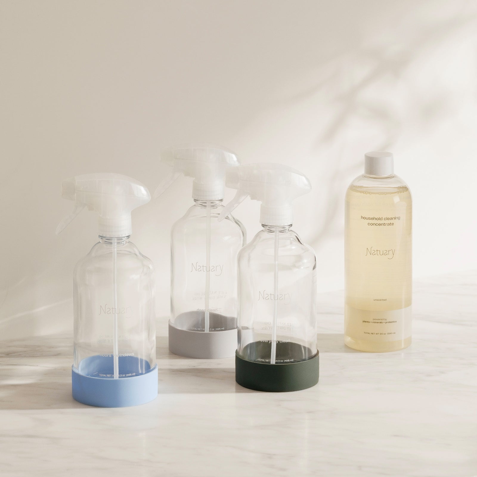 Set of clear bottles with colored bases on a light surface